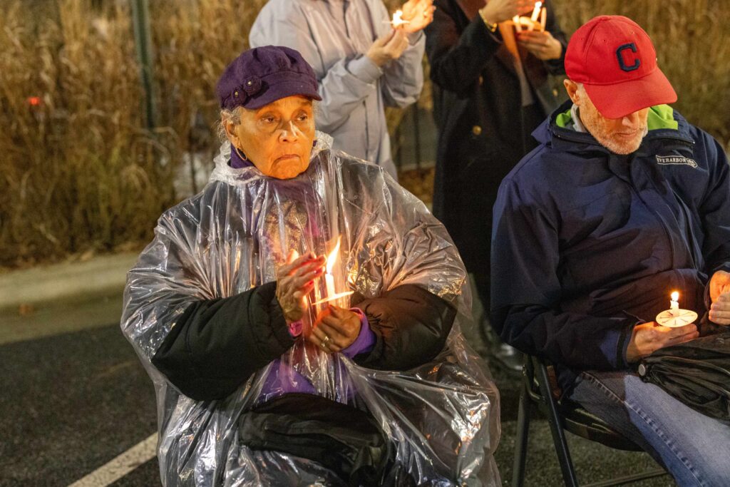 woman holding candle at memorial